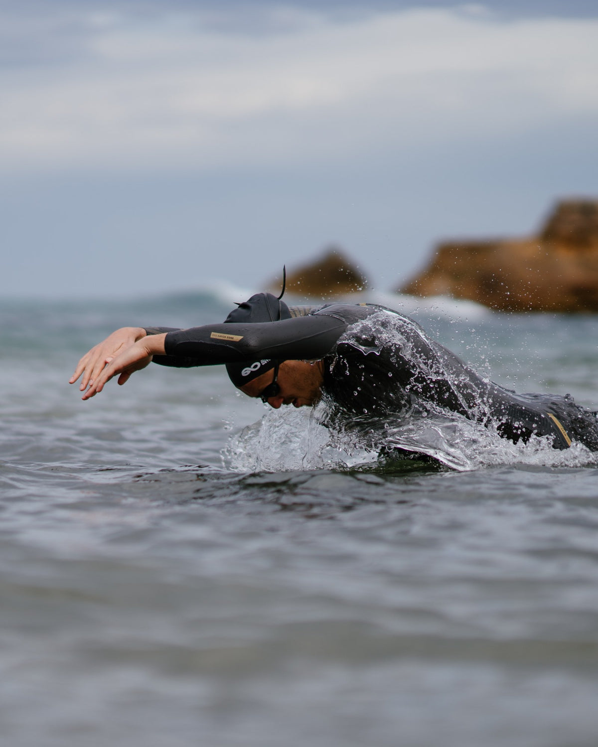 Swimmer in a Great Ocean wetsuit racing through the ocean